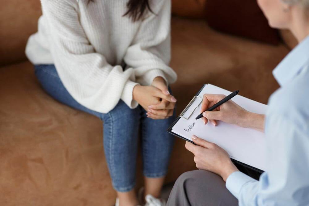 Psychologist Talking With Female Client Taking Notes